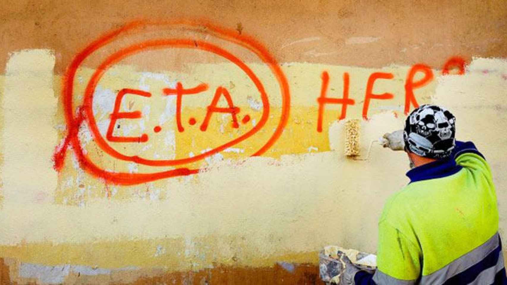 Un operario borra una pintada de la banda terrorista ETA / EFE