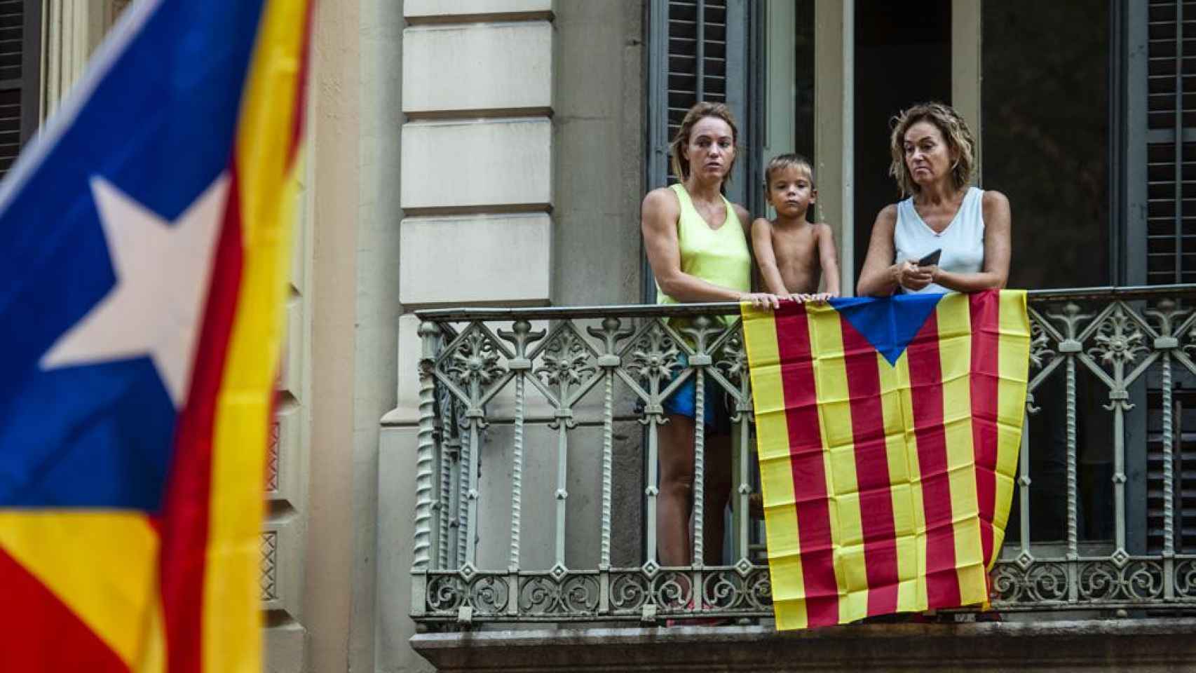 Una familia observa las movilizaciones de la Diada desde su balcón / MIGUEL OSÉS