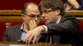 El 'conseller' Jordi Turull, junto al presidente Carles Puigdemont en una imagen de archivo del Parlament / EFE