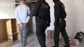 Agentes de Mossos con uno de los detenidos por robos violentos en Barcelona / MOSSOS
