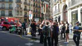 Bomberos y policías en una de las entradas de la parada Diagonal del metro de Barcelona afectada por el humo / CG