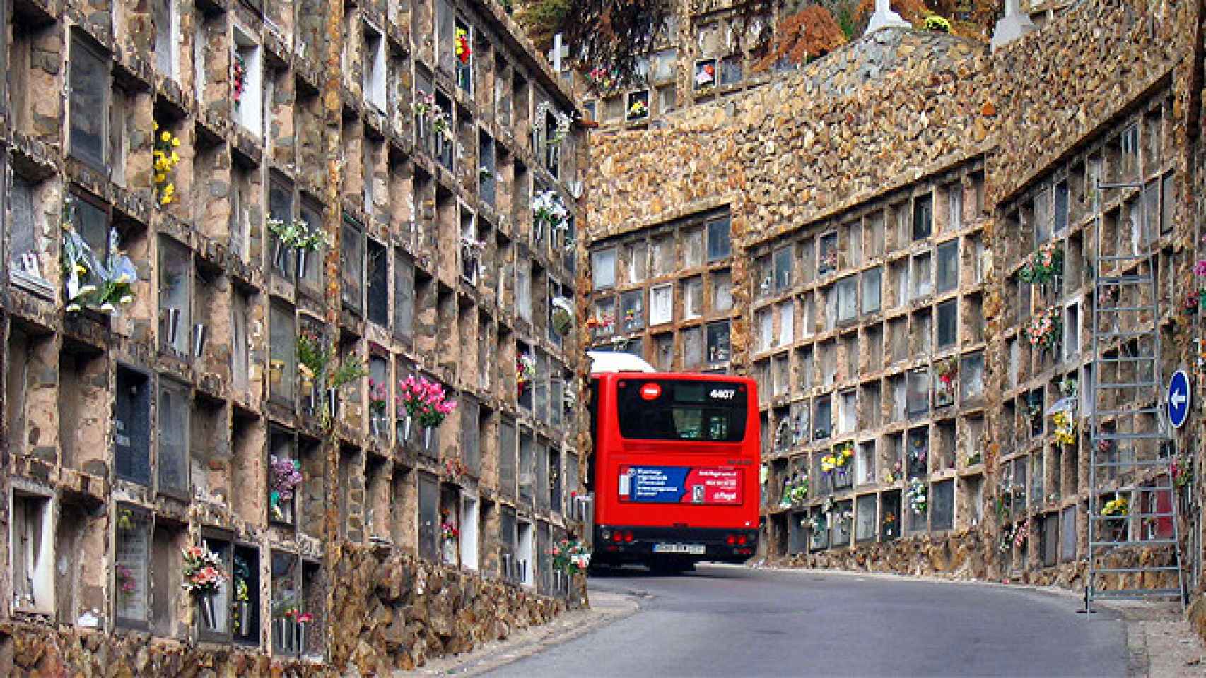 Un autobús passa entre las tumbas del cementerio de Montjuïc