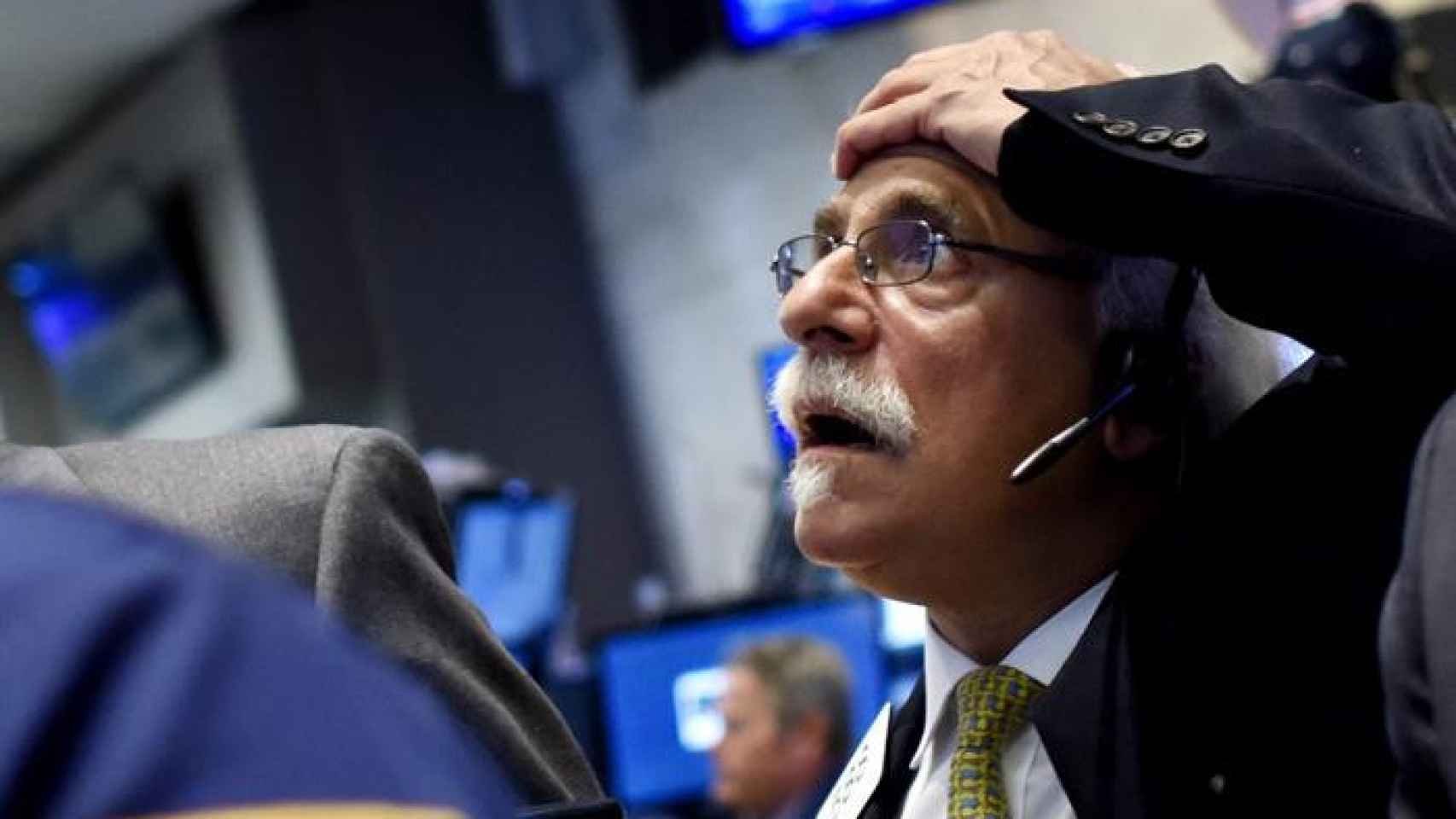 Un operador de Wall Street se lleva las manos a la cabeza durante el desplome de la apertura de la bolsa de Nueva York.