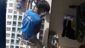 Un operario queda suspendido en la fachada después de que una vecina corte la cuerda /YOUTUBE