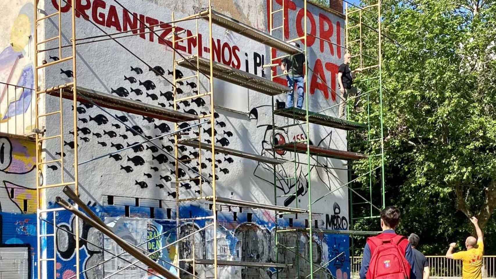 Un grupo de ultras independentistas, pintarrajeando la pared de un edificio en Bàscara / @salvaverges (TWITTER)