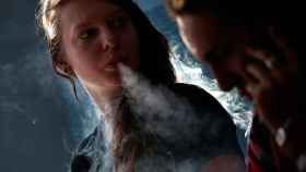 Una mujer 'vapea' un cigarrillo electrónico con un 'fumador' pasivo a su lado / CG