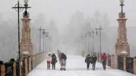 Varias personas caminan por una calle de Teruel con nieve el viernes / EFE