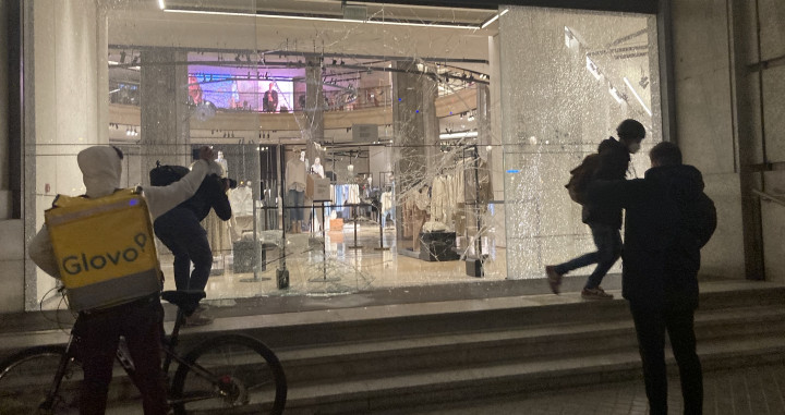 Un repartidor de Glovo capta los destrozos en una tienda de Zara en Barcelona / ELENA BURÉS