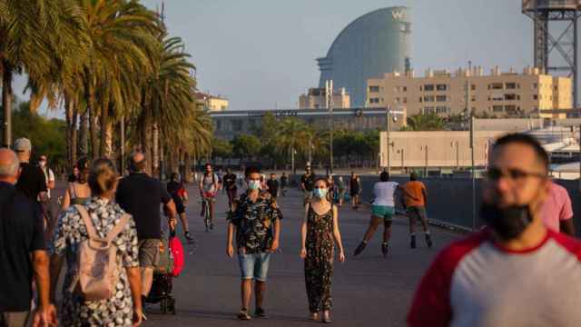 Turistas y vecinos de Barcelona pasean por la ciudad con el hotel W Barcelona de fondo / EP