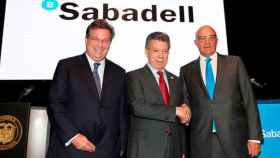 Jaime Gilinski, primer accionista del Sabadell, Juan Manuel Santos, presidente de Colombia, y Josep Oliu, presidente del banco.