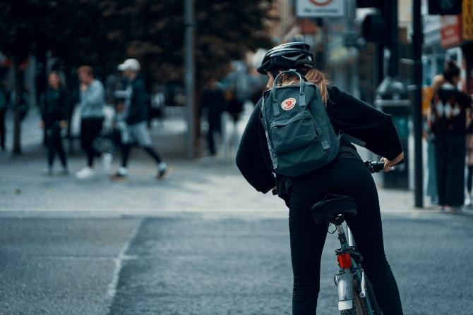 Mujer en bici y con su casco, obligatorio para menores de 16 años / Ross Sneddon en UNSPLASH