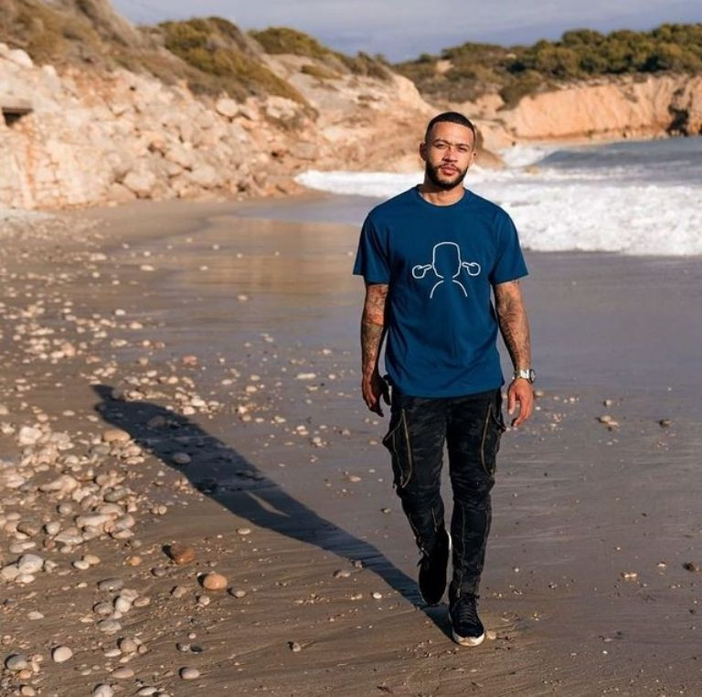 Memphis Depay, caminando por la playa con una de las camisetas de su marca / MEMPHIS