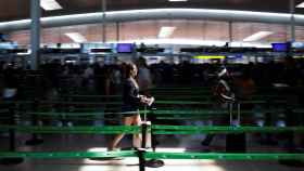 Dos personas en el control de seguridad del aeropuerto de El Prat / EFE