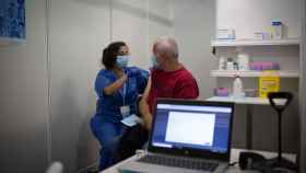 Una sanitaria vacuna a un hombre en el circuito de vacunación de Fira de Barcelona. Argimon / EUROPA PRESS