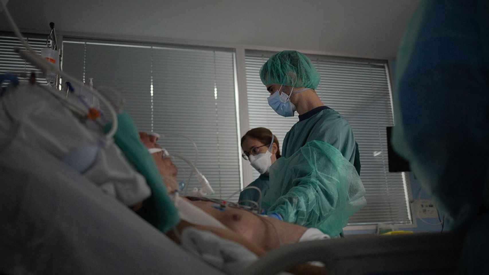 Personal sanitario visita a un enfermo ingresado en la uci del Hospital de la Santa Creu i Sant Pau / EUROPA PRESS