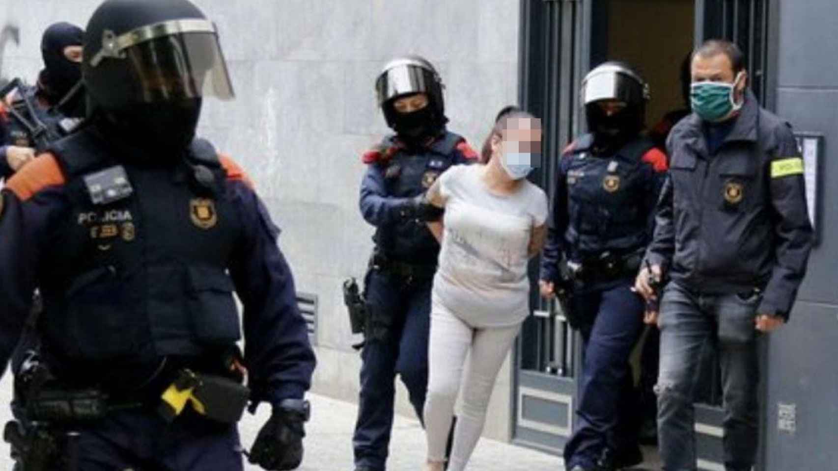 Mossos d'Esquadra con una detenida durante el operativo en Badalona / XAVIER GARCIA ALBIOL