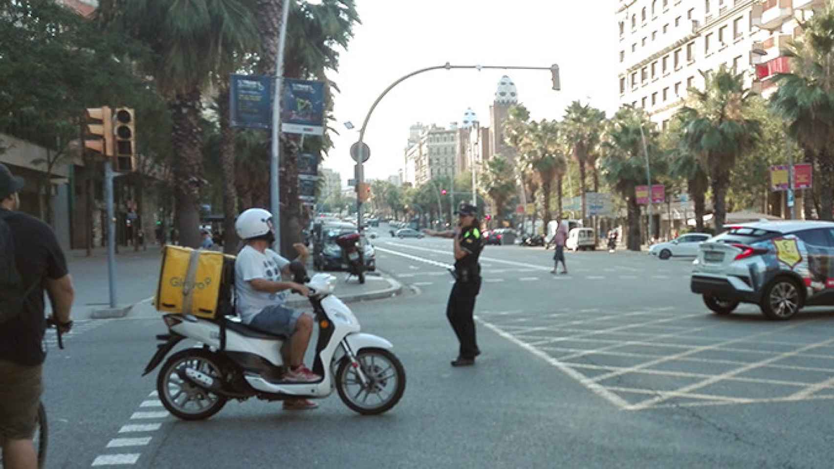 Una agente de policía dirige el tráfico junto a un semáforo apagado durante el corte de luz del 31 de julio en el cruce Casp y Marina de Barcelona / CG