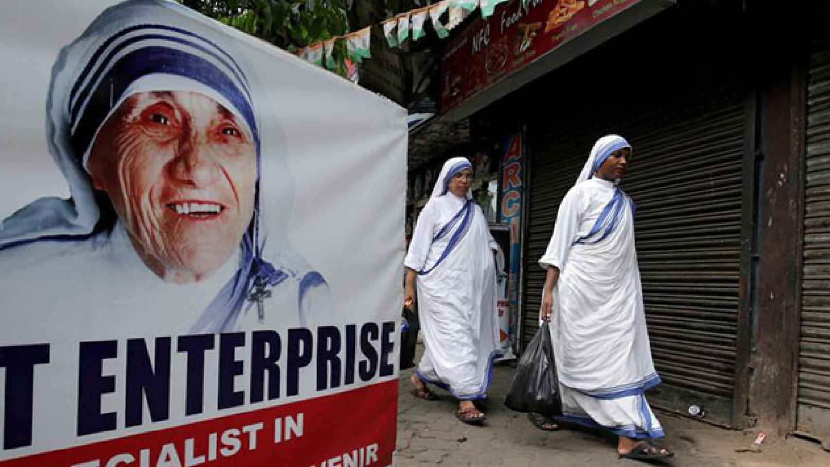 Dos Misioneras de la Caridad, ante un cartel de Teresa de Calcuta / EFE