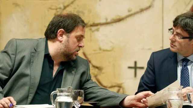 El expresidente de la Generalitat, Carles Puigdemont, conversa con el exvicepresidente Oriol Junqueras en una imagen de archivo / EFE