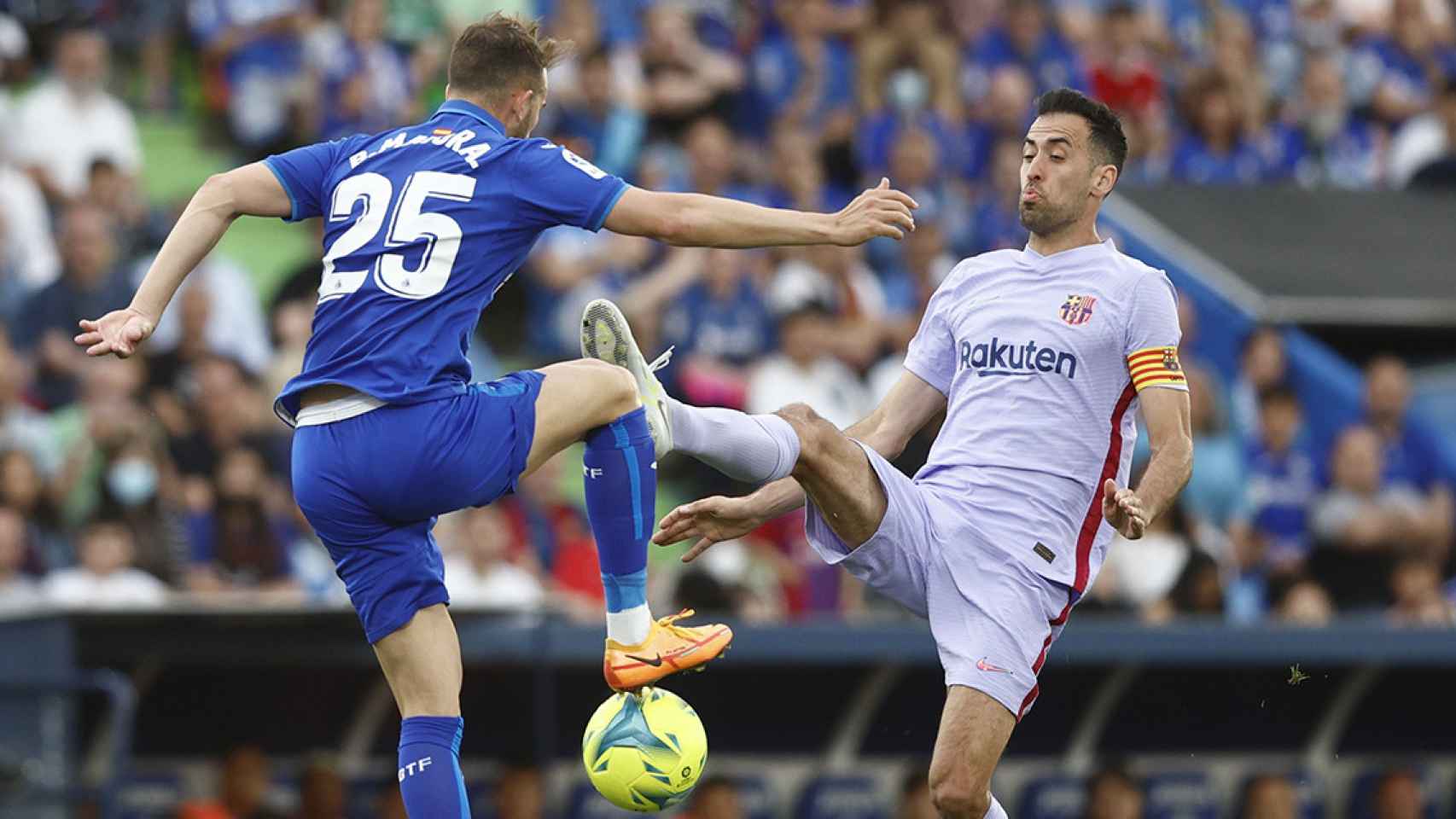 Busquets, disputando el balón contra Mayoral, durante el empate entre Getafe y Barça / EFE