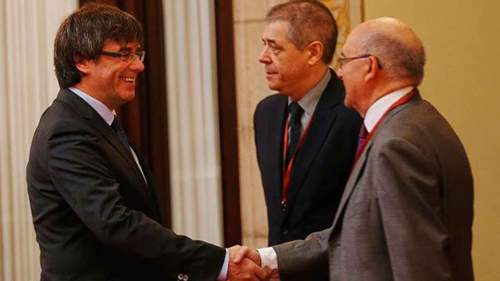 Carles Puigdemont saluda a Miguel Ángel Gimeno a la llegada de éste al Parlamento catalán esta mañana.