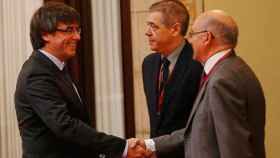 Carles Puigdemont saluda a Miguel Ángel Gimeno a la llegada de éste al Parlamento catalán esta mañana.