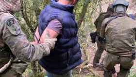 Imagen de uno de los detenidos con los agentes del Grupo Especial de Intervención (GEI) que han desmantelado una plantación en Susqueda / MOSSOS D'ESQUADRA