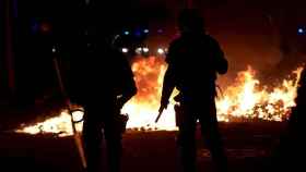 Un grupo de Mossos enfrente de una barricada, durante una de las protestas de la última semana / EFE