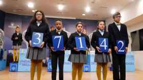 Los niños muestran el número agraciado con el primer premio del sorteo de El Niño, que ha caído íntegramente en Barcelona / EFE