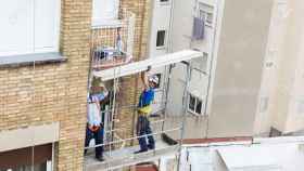 Trabajadores de la construcción reparando una fachada