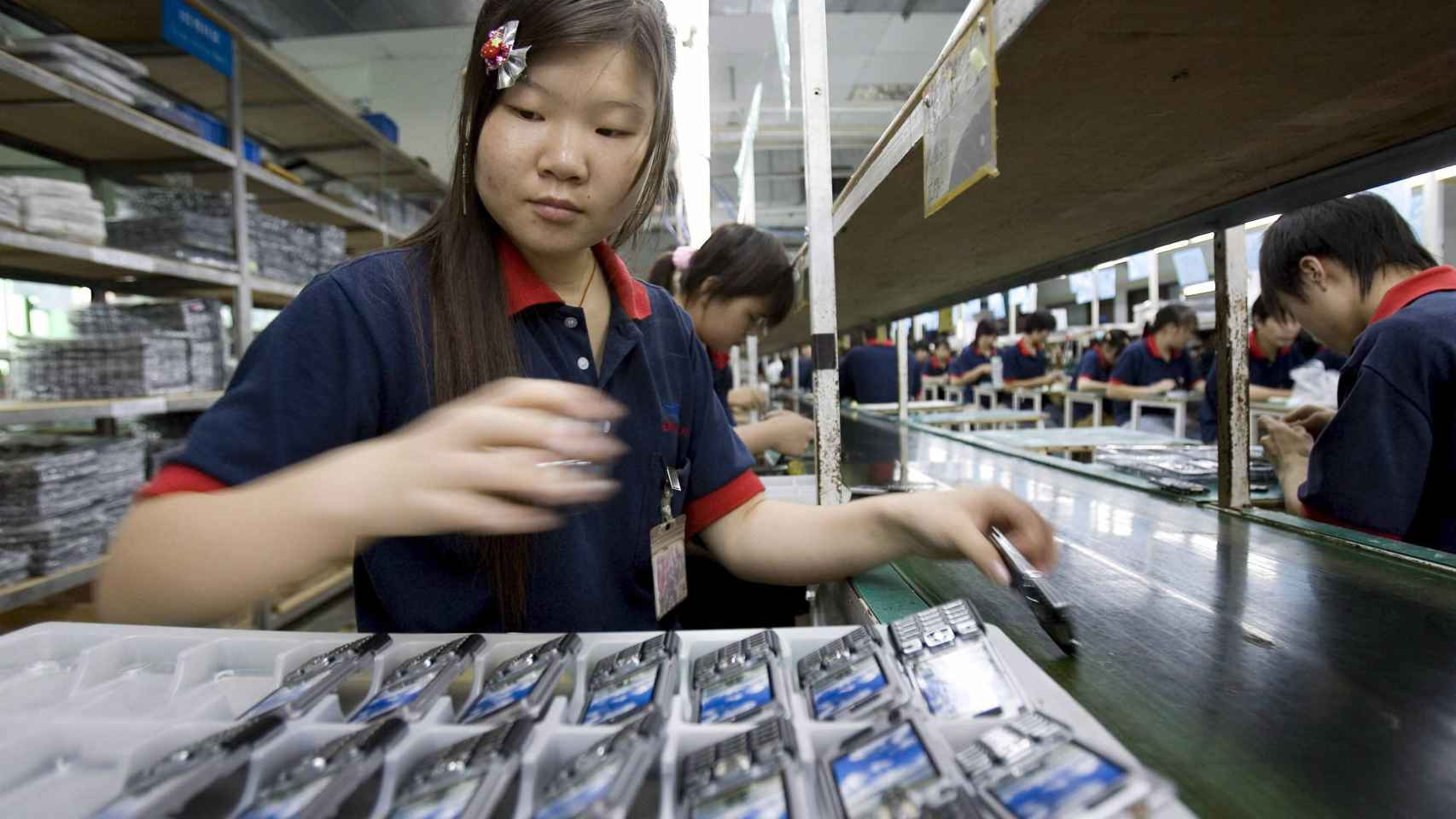 Una mujer china trabaja con teléfonos móviles / EFE