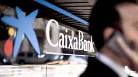 Un cliente ante una oficina de Caixabank, una de las empresas de la banca que alerta de los riesgos en Cataluña / CG