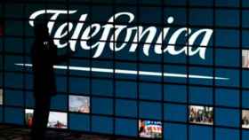 Un hombre mira una pantalla con el logo de Telefónica / EFE