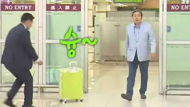 Kim Moo-Sung lanza la maleta a su asistente