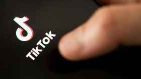 Un joven presiona el logo de Tiktok en su teléfono móvil / EP