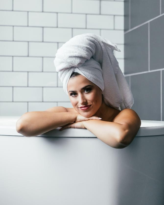 Chica con el pelo enrollado en una toalla tras la ducha / Spencer Davis en UNSPLASH