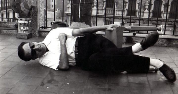 Joan Brossa, tirado en el suelo en una célebre fotografía de Roman Ferrer. ARXIU MACBA / FUNDACIÓN J. BROSSA