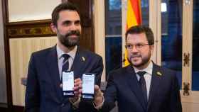 El 'conseller' de Empresa y Trabajo, Roger Torrent (i), y el presidente de la Generalitat, Pere Aragonès (d), con el móvil en la mano / EUROPA PRESS