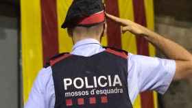 Imagen de un agente de los Mossos d'Esquadra saludando a una estelada en Vic (Barcelona) / EFE