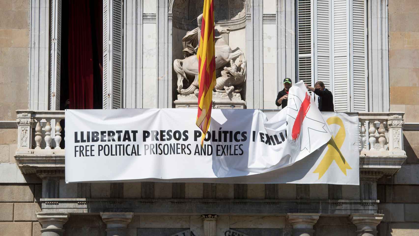 Momento en el que personal de la Generalitat quita la simbología independentista del Palau de la Generalitat / Irrelevancia EFE