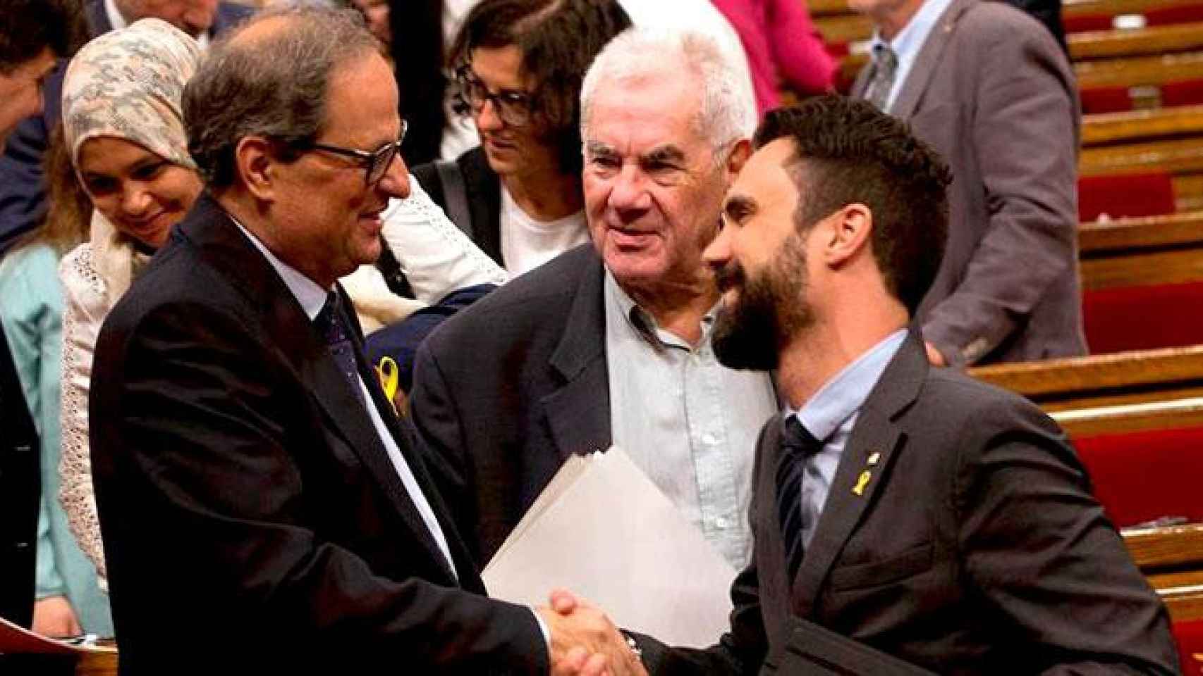 El candidato a la presidencia de la Generalitat Quim Torra (i) saluda al presidente de la cámara Roger Torrent (d), en presencia del diputado Ernest Maragall (c) en el Parlament / EFE