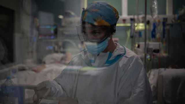 Una trabajadora sanitaria atiende a los pacientes ingresados por Covid en la uci de un hospital de Cataluña / David Zorrakino (EP)