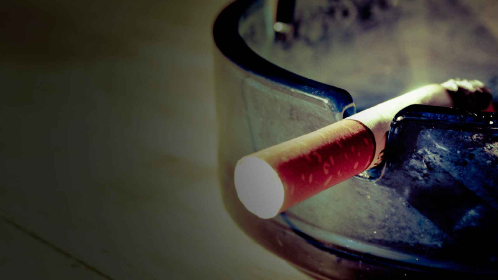 Un cigarrillo se consume en un cenicero día/ CG