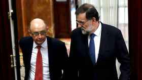 El presidente del Gobierno, Mariano Rajoy (d), y el ministro de Hacienda y Función Pública, Cristóbal Montoro (i), en una imagen de archivo en los pasillos del Congreso de los Diputados; la financiación autonómica, a debate / EFE
