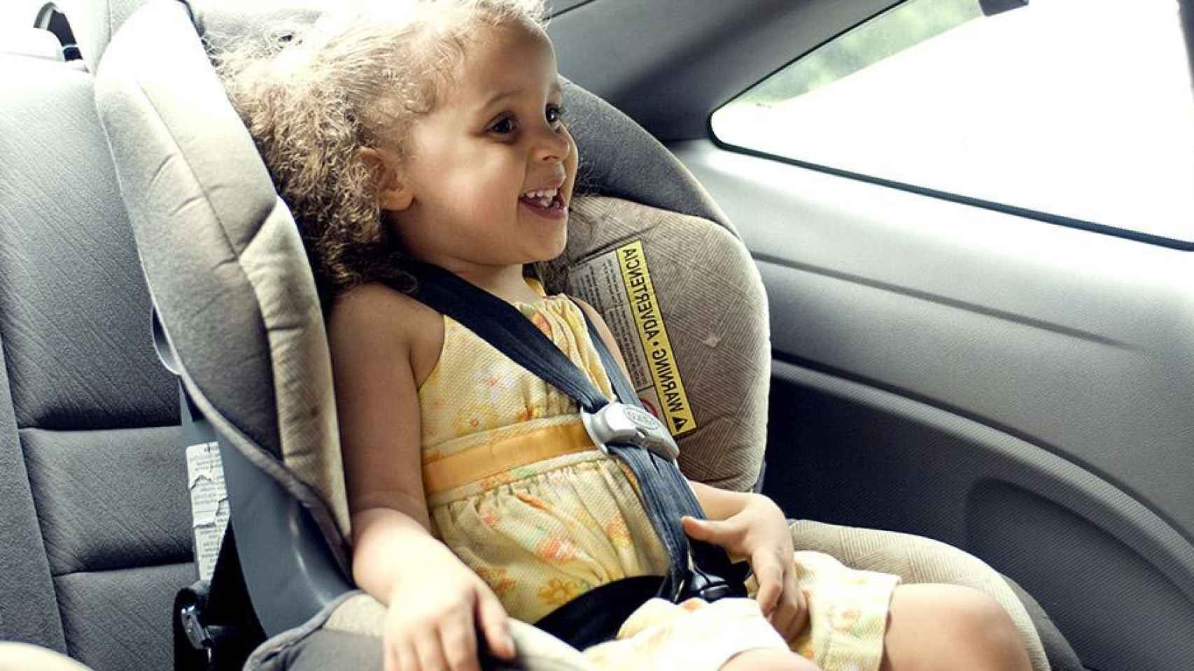 Una niña viajando en coche en una sillita homologada / PIXNIO Los padres españoles pone en peligro a sus hijos
