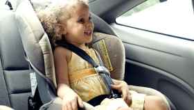 Una niña viajando en coche en una sillita homologada / PIXNIO Los padres españoles pone en peligro a sus hijos