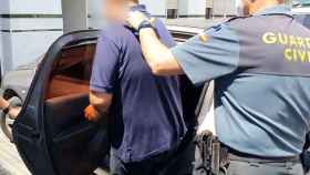 Un agente acompaña a un detenido al coche / GUARDIA CIVIL