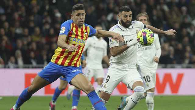 Benzema disputa el balón contra Paulista, durante el triunfo del Real Madrid contra el Valencia / EFE