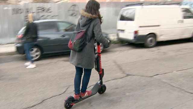 Una mujer conduce un patinete eléctrico / EP
