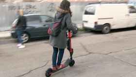 Una mujer conduce un patinete eléctrico / EP